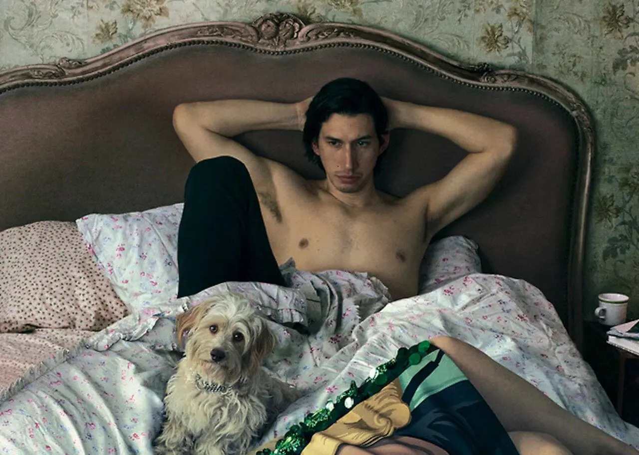 Adam Driver stripped down in bed.